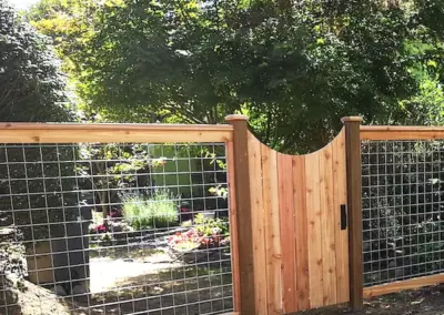 Wood and hog wire fence with custom wooden gate installed in Seattle backyard