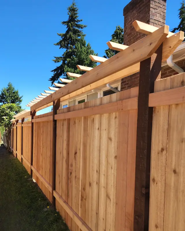 Custom cedar privacy fence with decorative pergola top installed for a residential property in Seattle<br />
