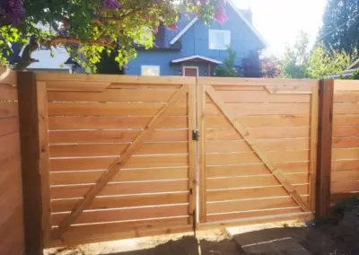 Custom double wooden gate installation in Seattle with horizontal cedar fence