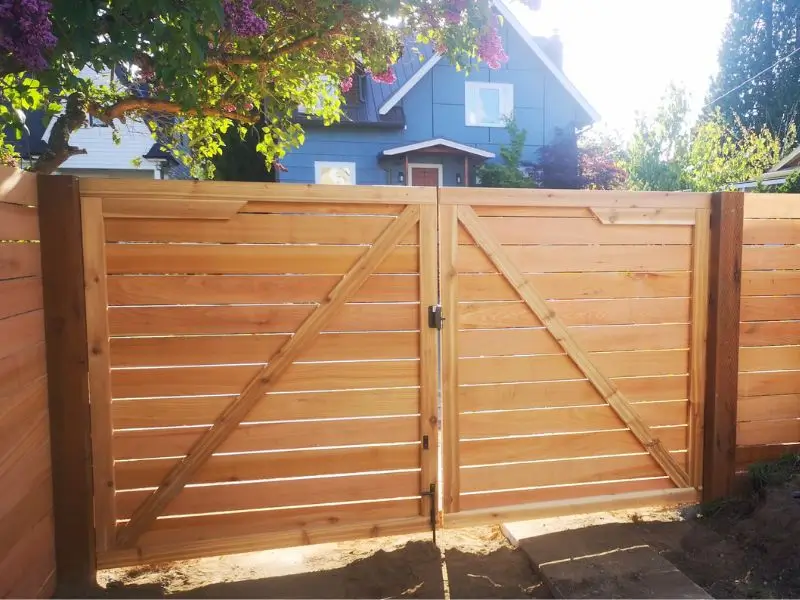 Custom double wooden gate installation in Seattle with horizontal cedar fence<br />
