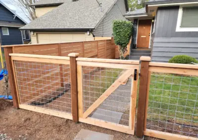 wood and wire garden fence with gate in Seattle backyard