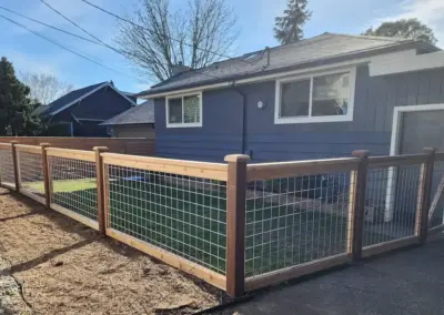 Residential wood fence with wire mesh panels and landscaping