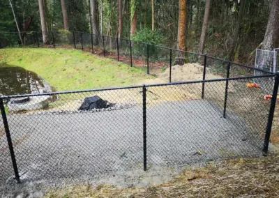 Black chain link fence installation on sloped terrain for pet and property safety